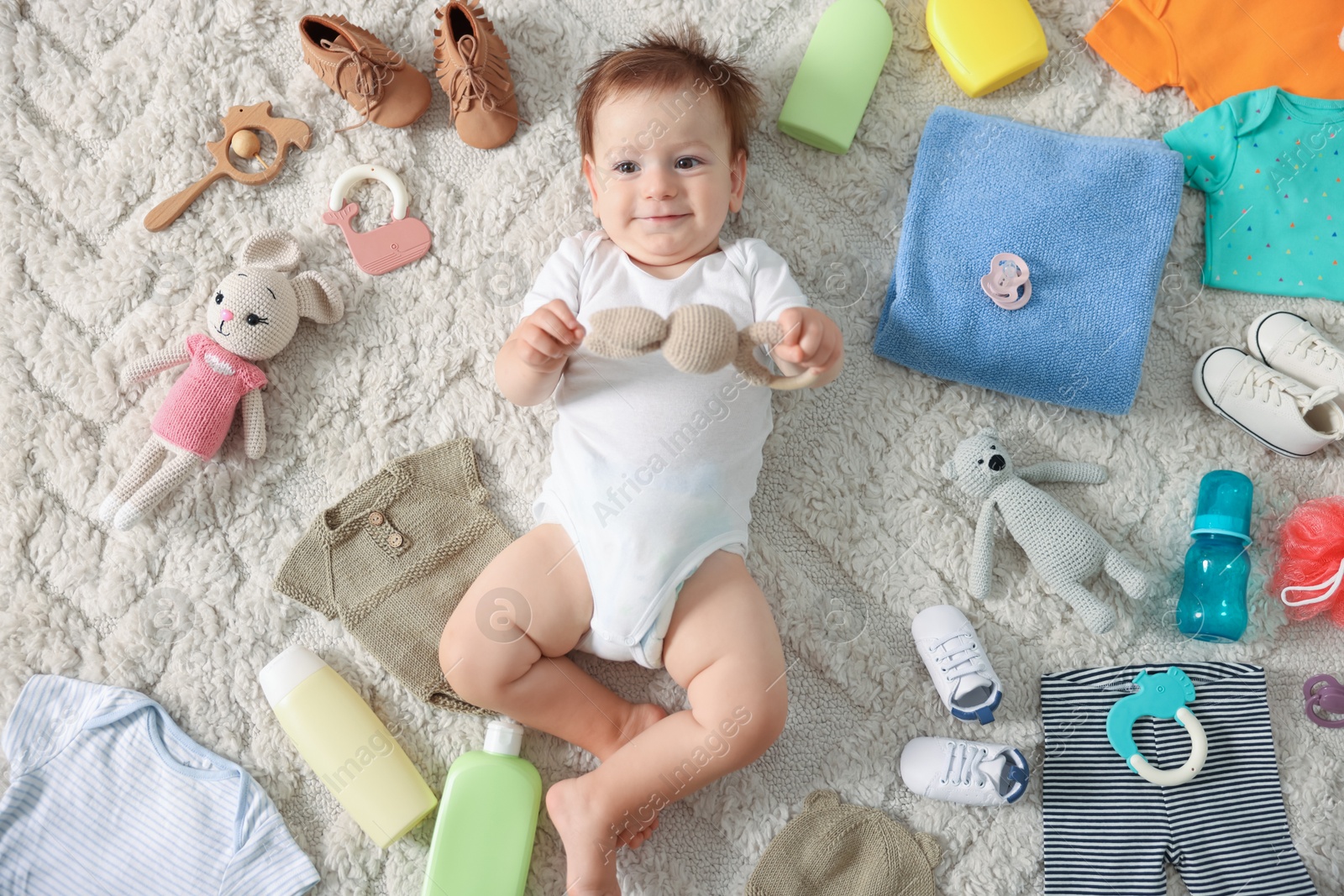 Photo of Cute baby, different clothes and accessories on floor, top view