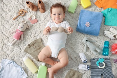 Photo of Cute baby, different clothes and accessories on floor, top view