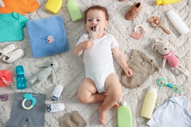 Photo of Cute baby, different clothes and accessories on floor, top view