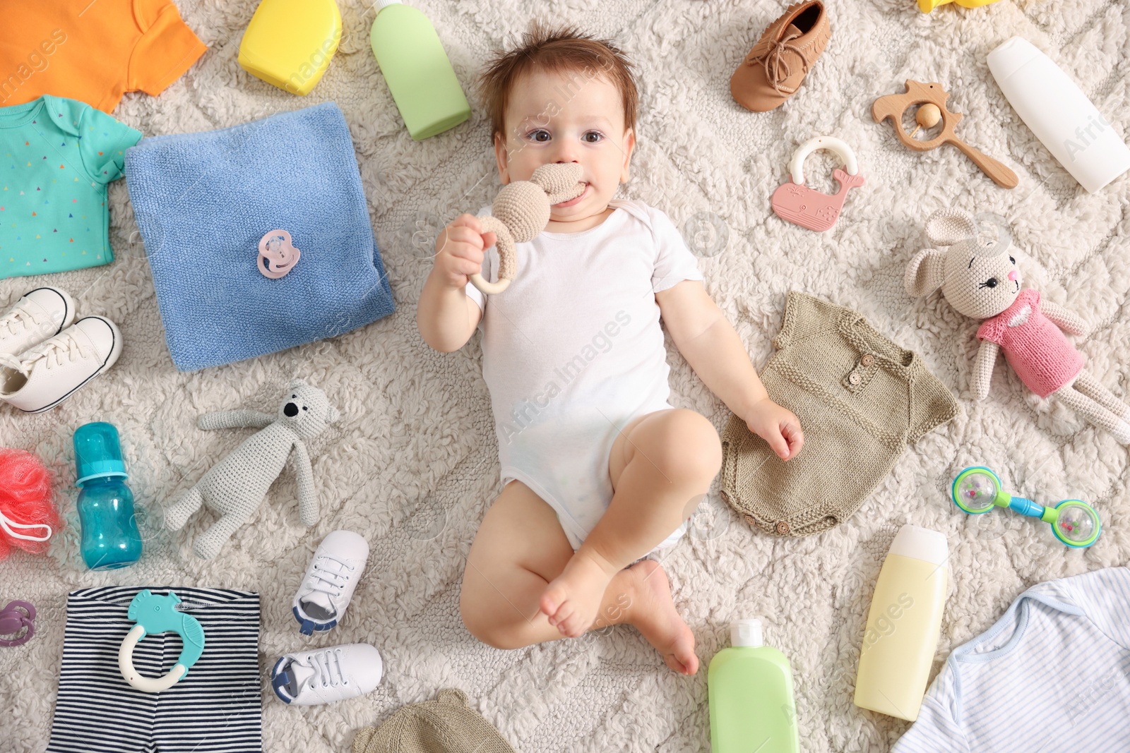 Photo of Cute baby, different clothes and accessories on floor, top view
