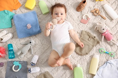 Photo of Cute baby, different clothes and accessories on floor, top view