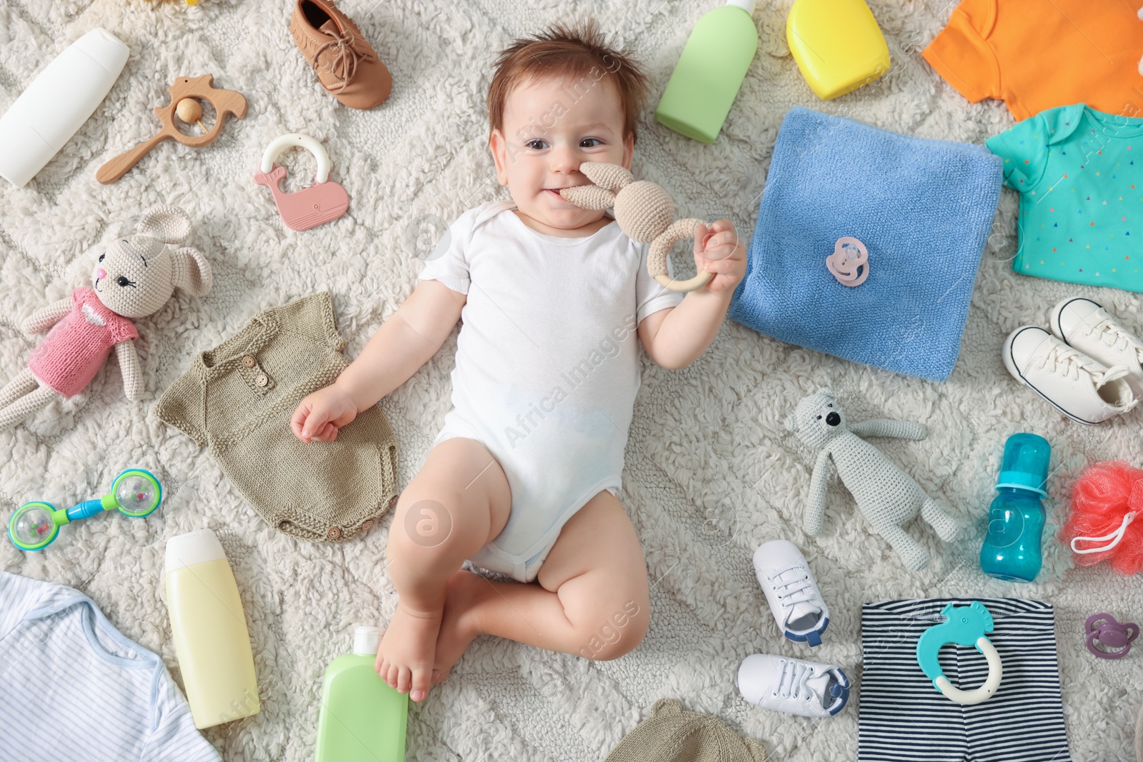 Photo of Cute baby, different clothes and accessories on floor, top view