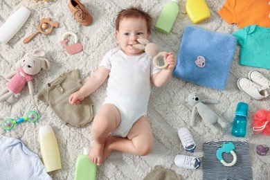 Photo of Cute baby, different clothes and accessories on floor, top view