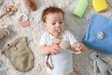 Photo of Cute baby, different clothes and accessories on floor, top view
