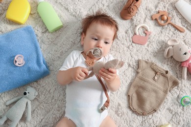 Photo of Cute baby, different clothes and accessories on floor, top view