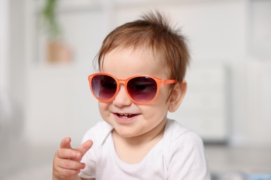 Photo of Cute baby with stylish sunglasses at home