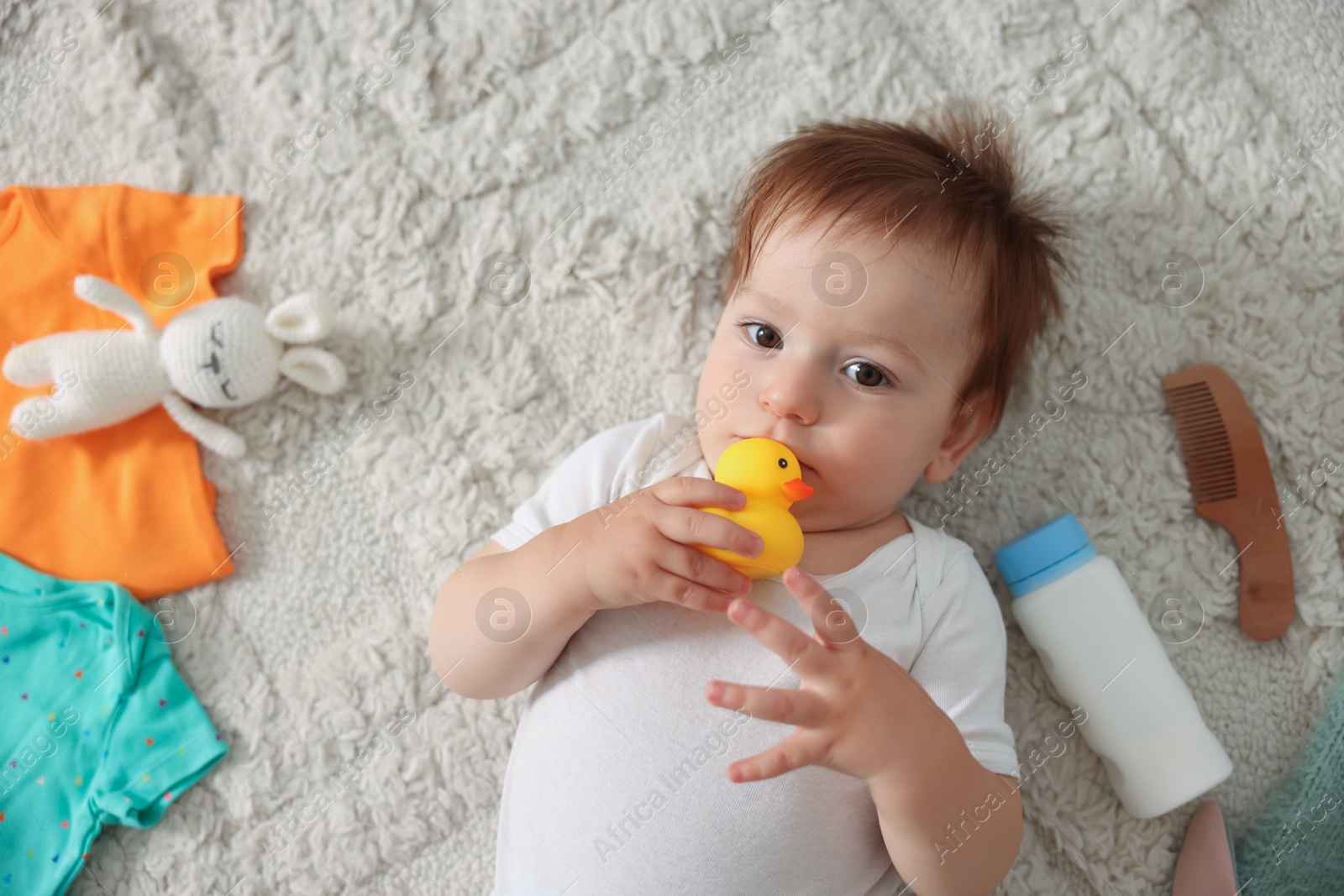 Photo of Cute baby, different clothes and accessories on floor, top view