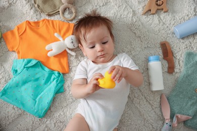 Photo of Cute baby, different clothes and accessories on floor, top view