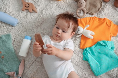 Photo of Cute baby, different clothes and accessories on floor, top view