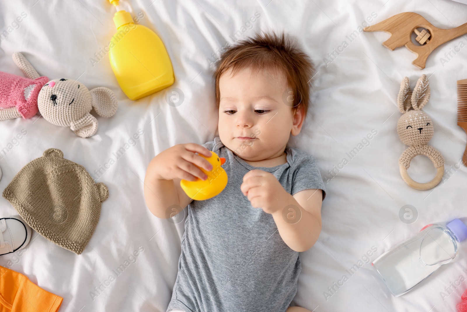 Photo of Cute baby and different accessories on bed, top view
