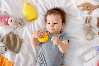 Photo of Cute baby and different accessories on bed, top view