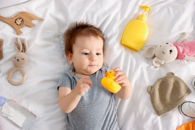 Photo of Cute baby and different accessories on bed, top view