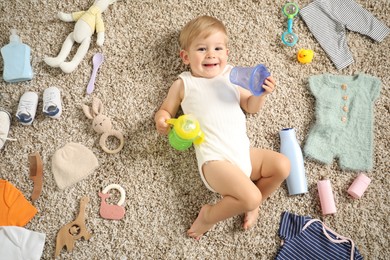 Photo of Cute baby, different clothes and accessories on floor, top view