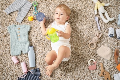 Photo of Cute baby, different clothes and accessories on floor, top view