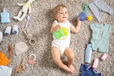Photo of Cute baby, different clothes and accessories on floor, top view