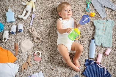 Photo of Cute baby, different clothes and accessories on floor, top view