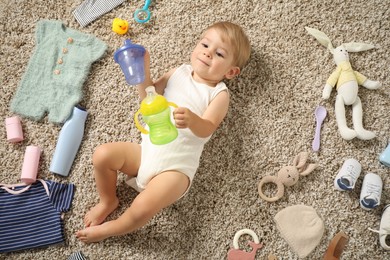 Photo of Cute baby, different clothes and accessories on floor, top view