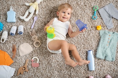 Photo of Cute baby, different clothes and accessories on floor, top view