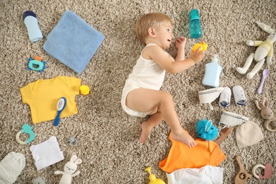 Photo of Cute baby, different clothes and accessories on floor, top view
