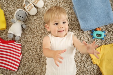 Photo of Cute baby, different clothes and accessories on floor, top view