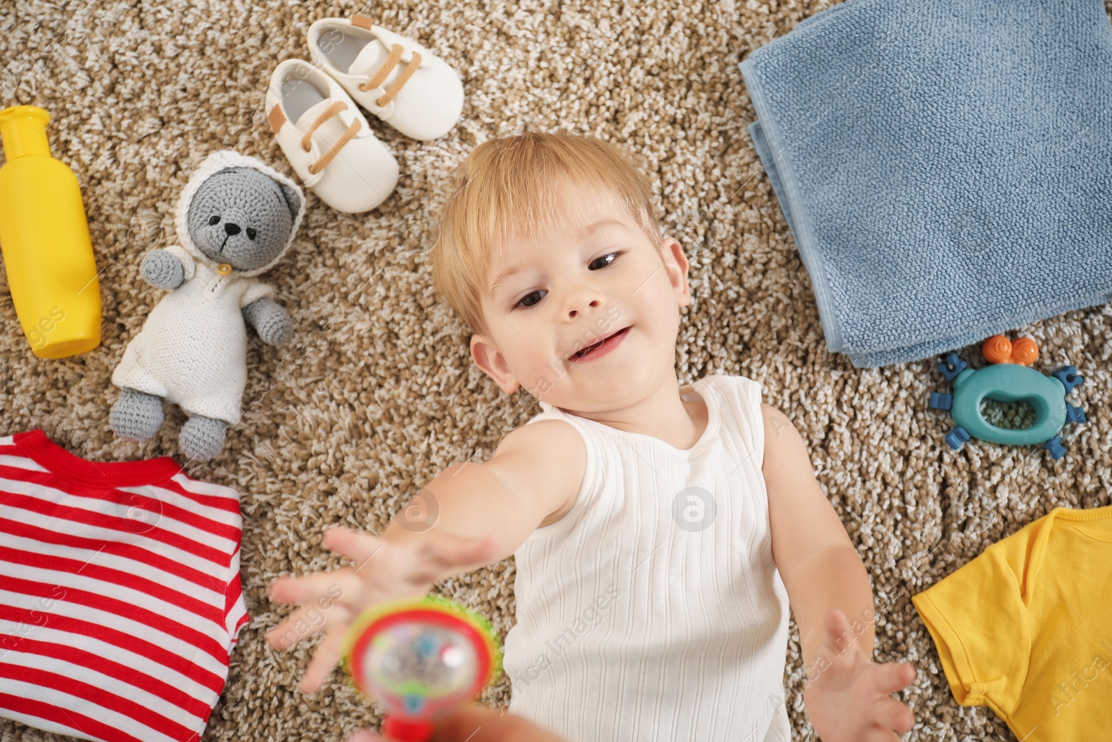 Photo of Cute baby, different clothes and accessories on floor, top view