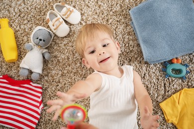 Photo of Cute baby, different clothes and accessories on floor, top view
