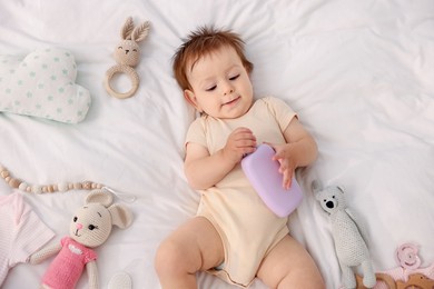 Photo of Cute baby and different accessories on bed, top view