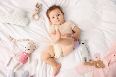 Photo of Cute baby and different accessories on bed, top view