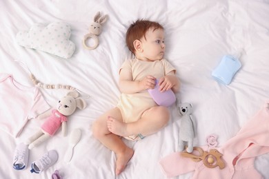 Photo of Cute baby and different accessories on bed, top view