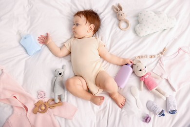 Photo of Cute baby and different accessories on bed, top view