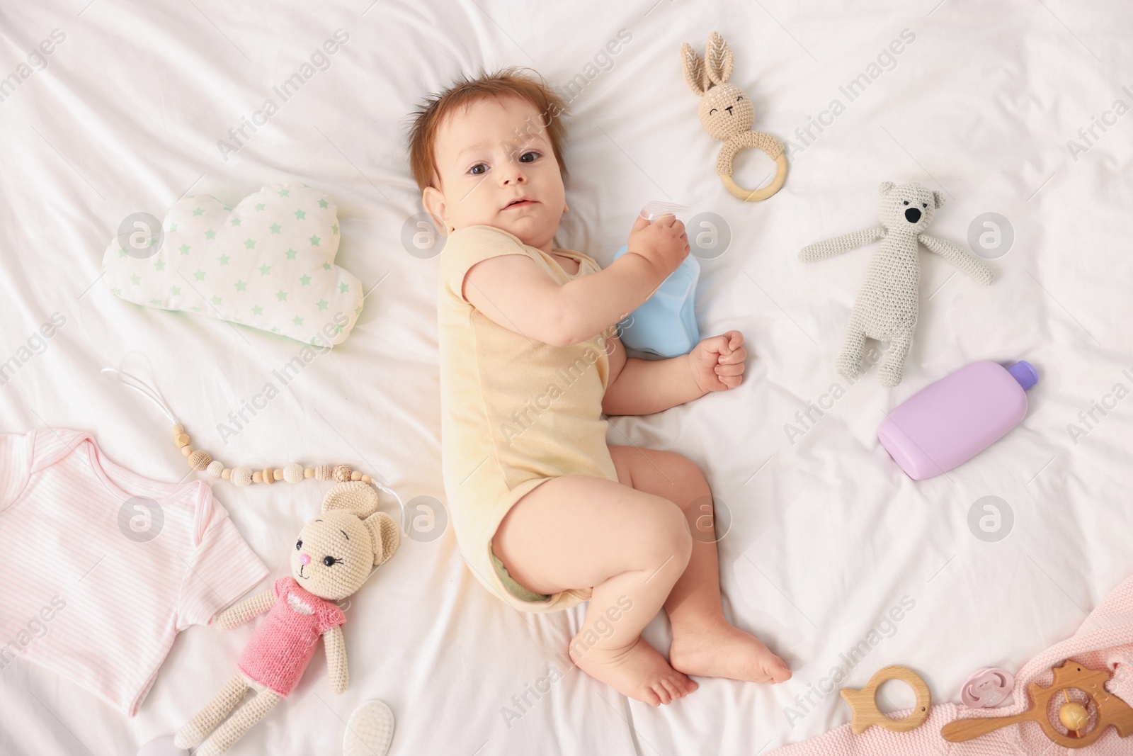 Photo of Cute baby and different accessories on bed, top view