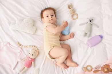 Photo of Cute baby and different accessories on bed, top view