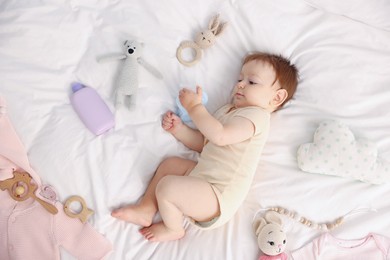 Photo of Cute baby and different accessories on bed, top view