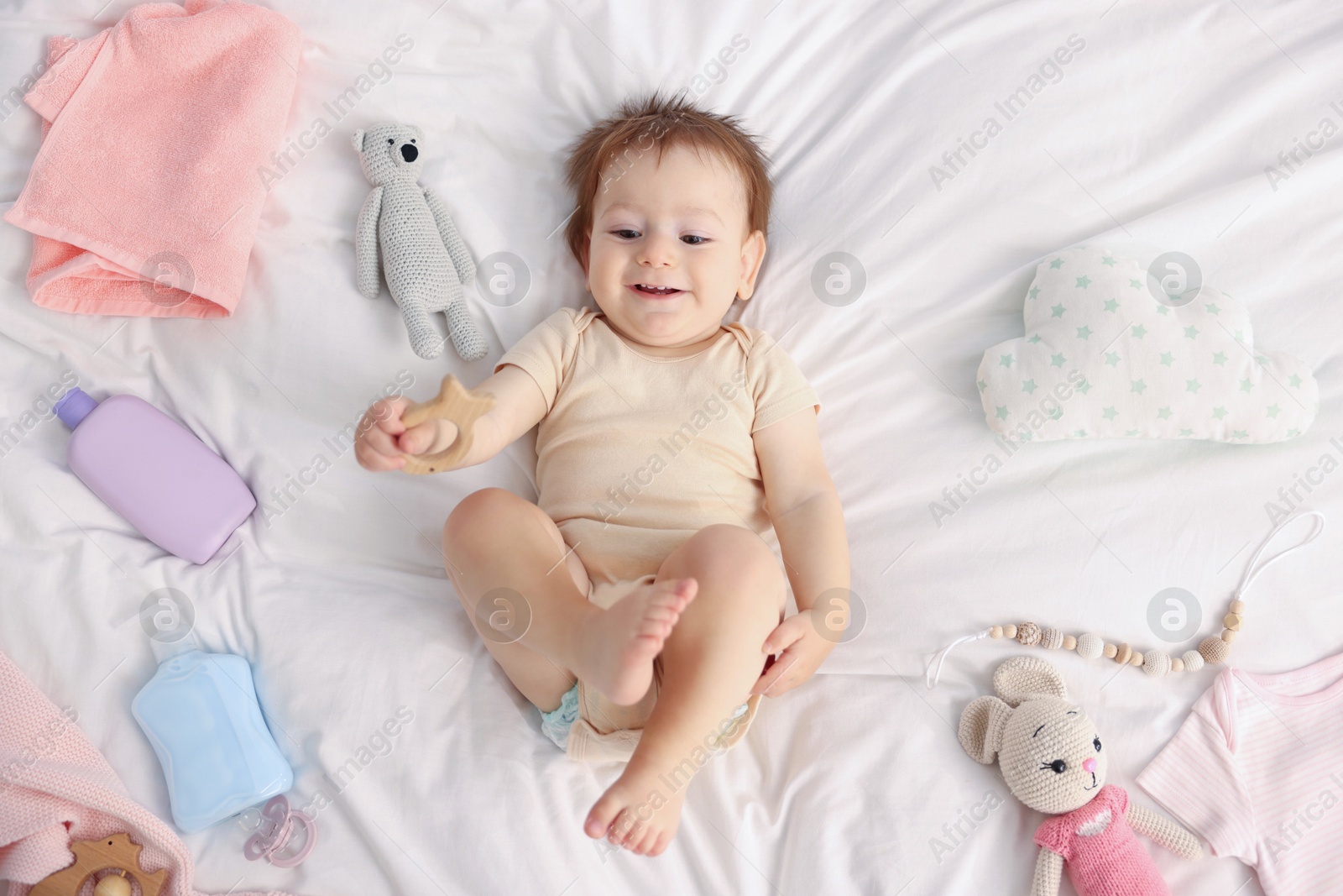 Photo of Cute baby and different accessories on bed, top view