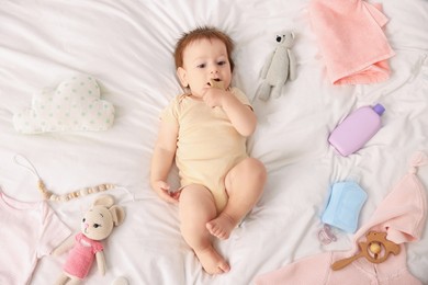 Photo of Cute baby and different accessories on bed, top view