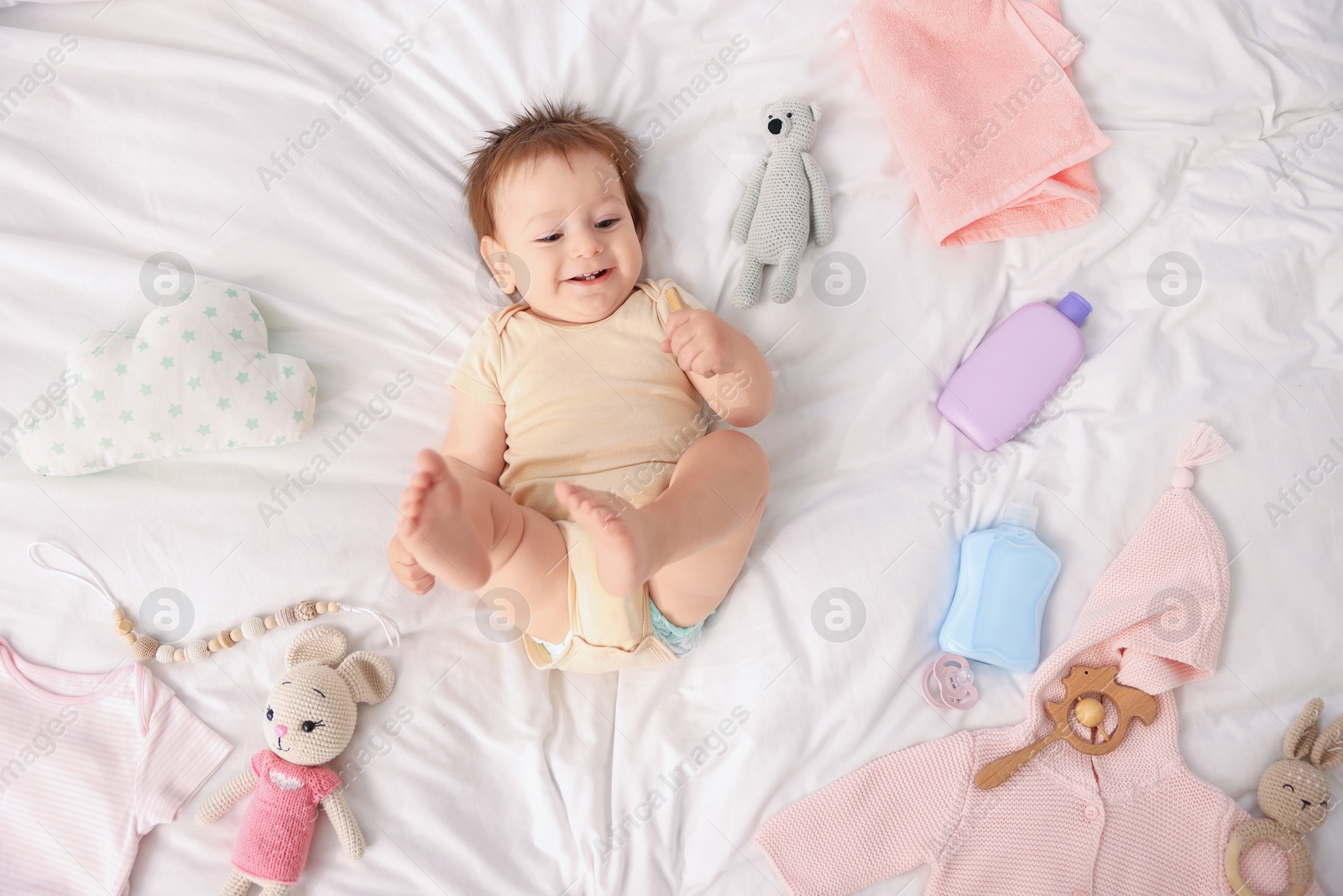 Photo of Cute baby and different accessories on bed, top view