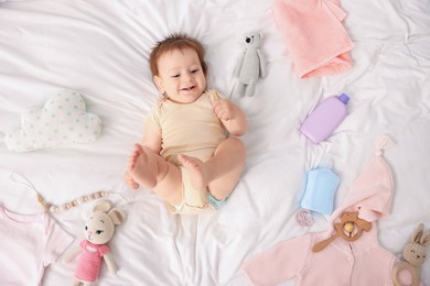 Photo of Cute baby and different accessories on bed, top view