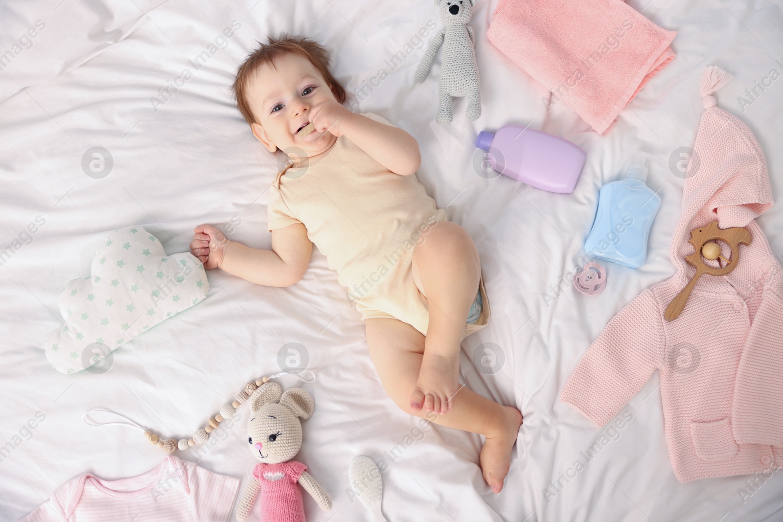 Photo of Cute baby and different accessories on bed, top view