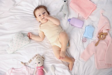Photo of Cute baby and different accessories on bed, top view