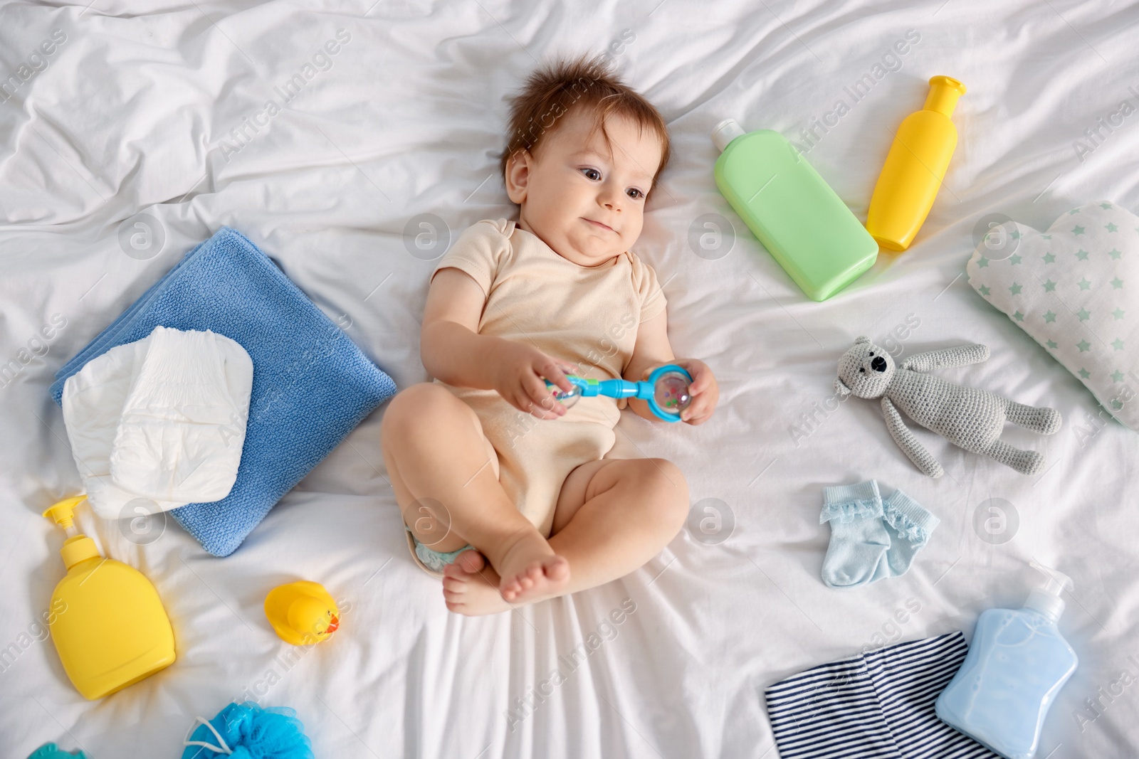Photo of Cute baby and different accessories on bed, top view