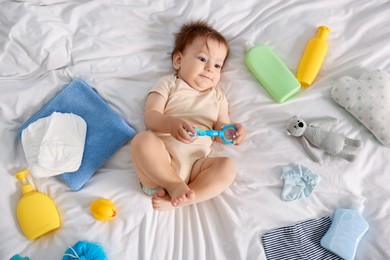Photo of Cute baby and different accessories on bed, top view