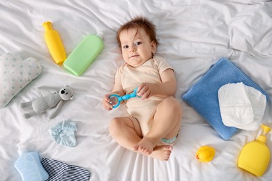Photo of Cute baby and different accessories on bed, top view