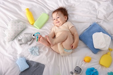 Photo of Cute baby and different accessories on bed, top view