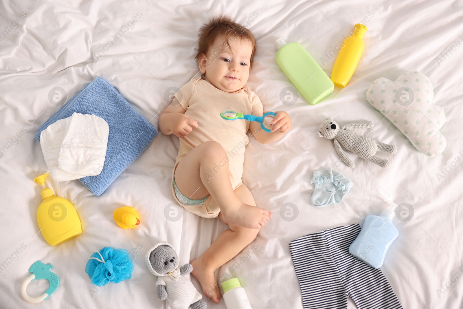 Photo of Cute baby, different clothes and accessories on bed, top view