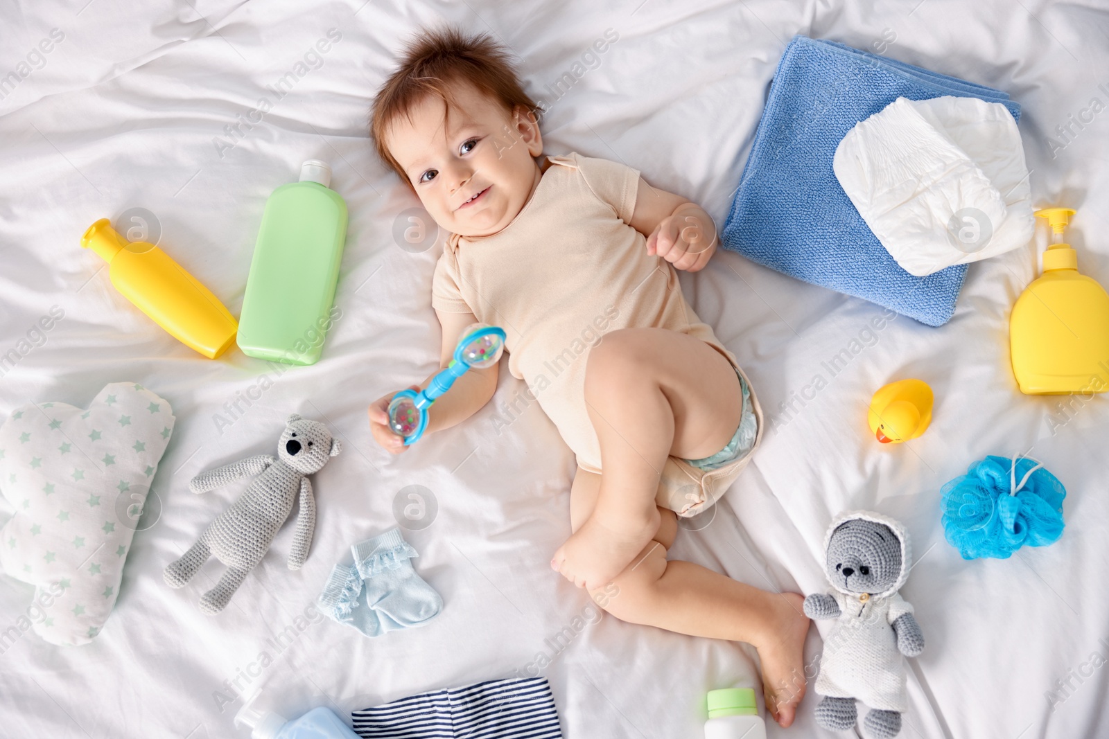 Photo of Cute baby, different clothes and accessories on bed, top view