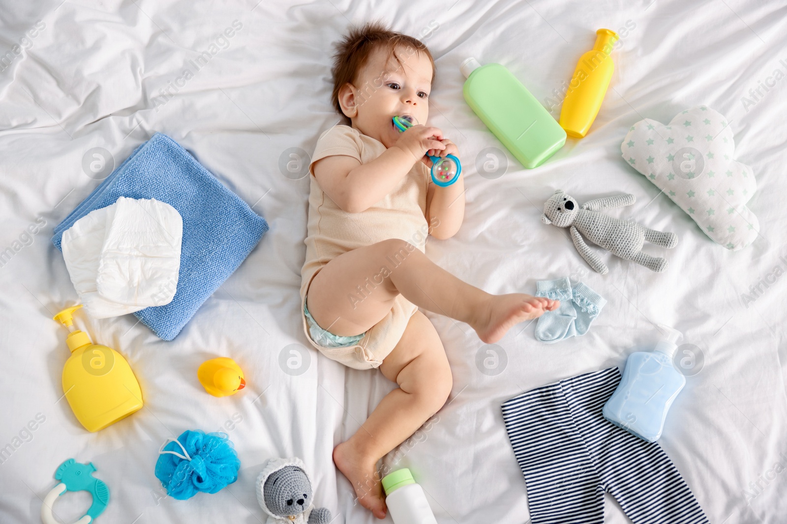Photo of Cute baby, different clothes and accessories on bed, top view