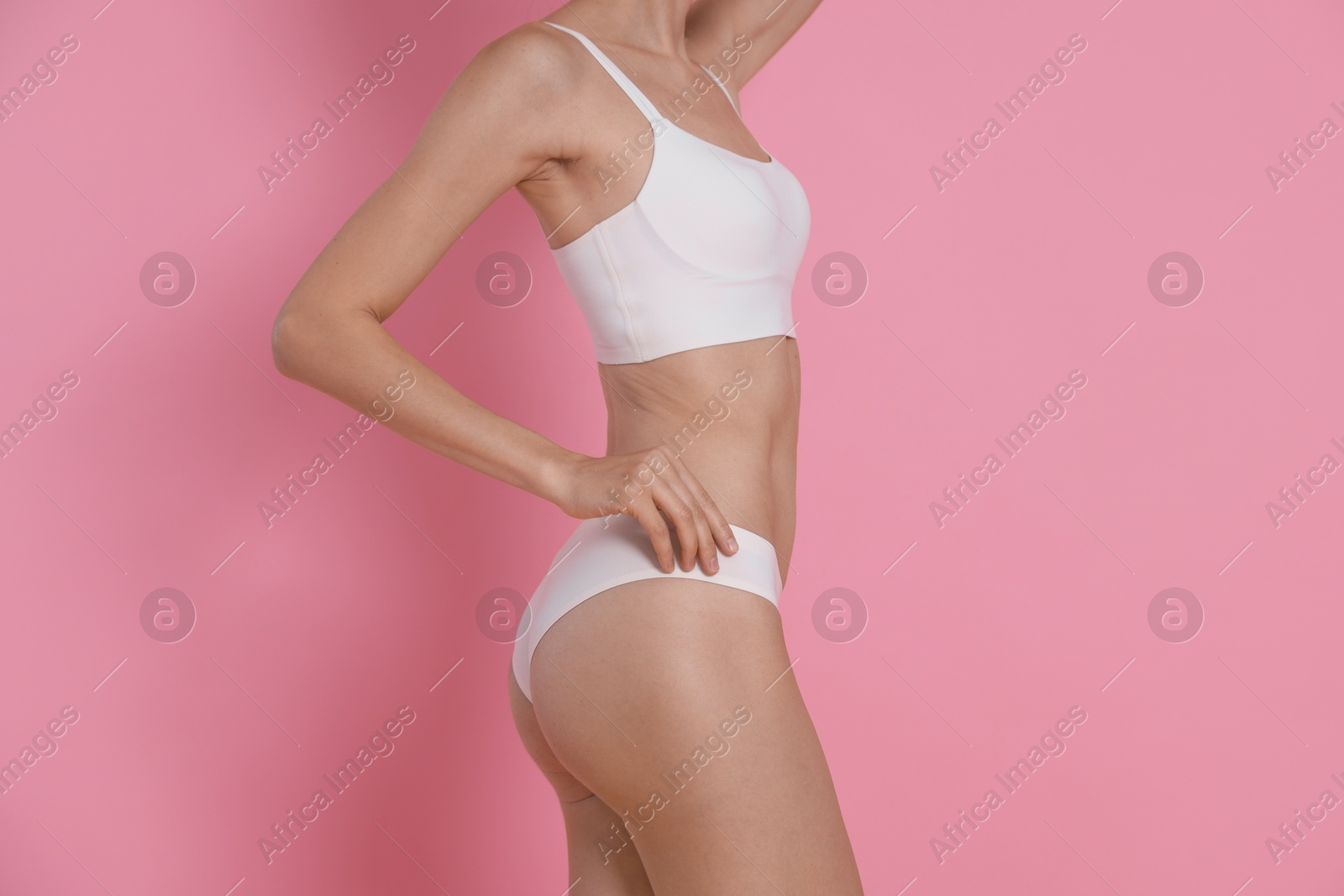 Photo of Woman with slim body on pink background, closeup