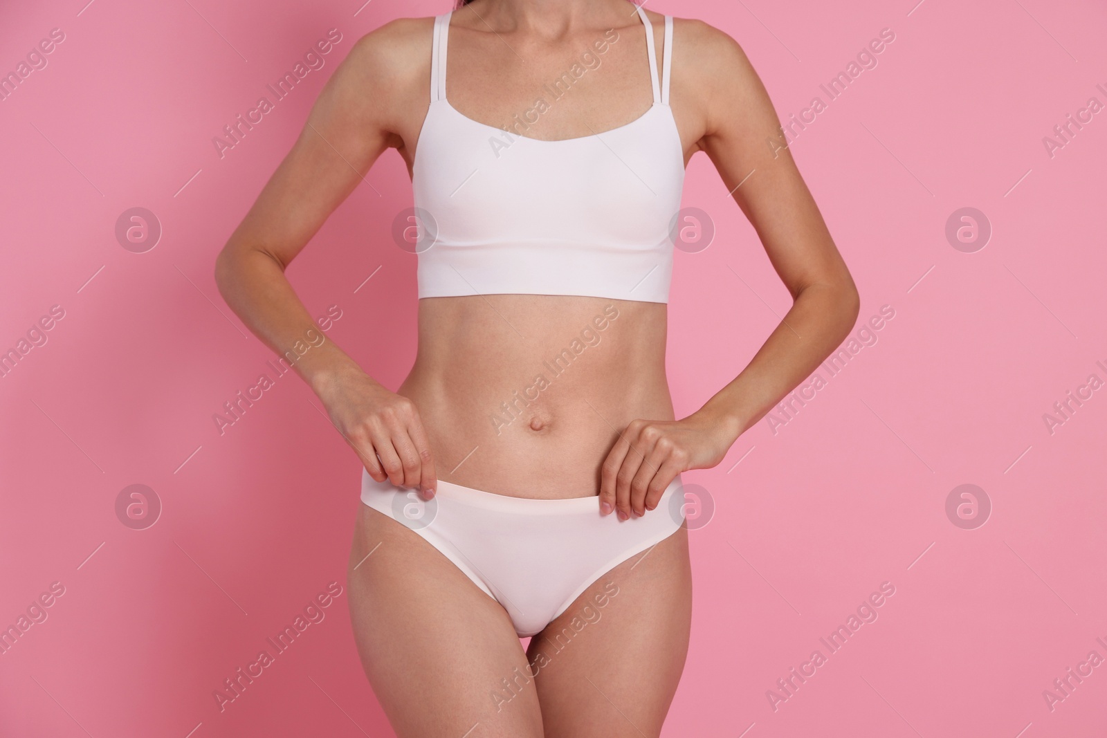 Photo of Woman with slim body on pink background, closeup