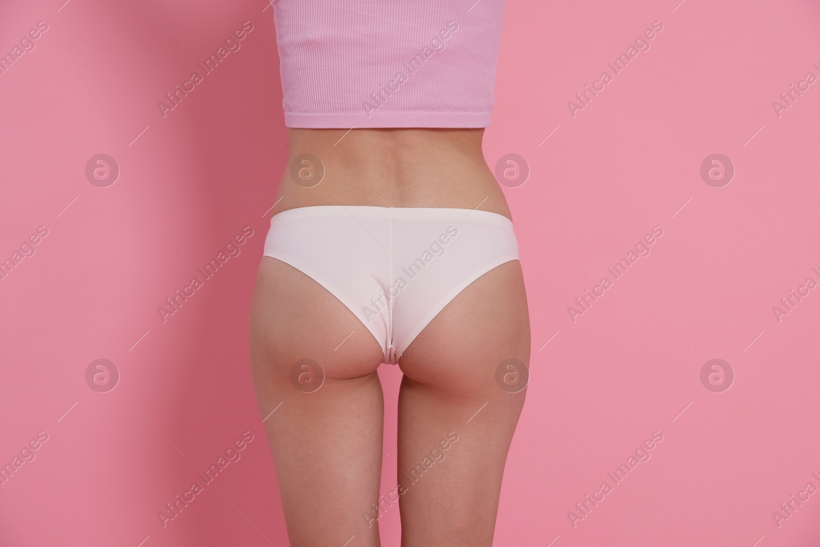 Photo of Woman with slim body on pink background, closeup