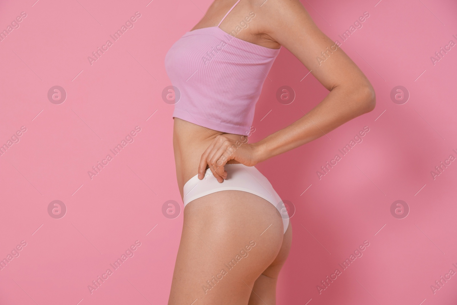 Photo of Woman with slim body on pink background, closeup